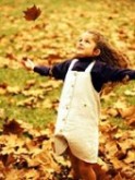 young girl playing in leaves